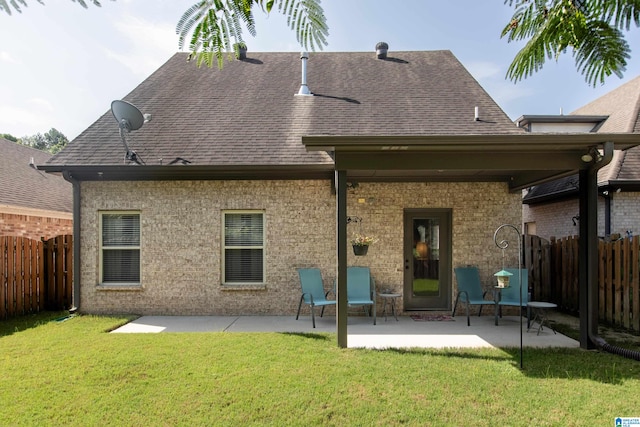 back of property with a lawn and a patio area