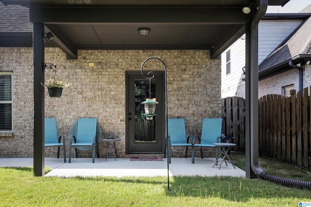 property entrance with a lawn and a patio area