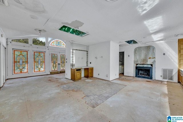 unfurnished living room featuring lofted ceiling and a premium fireplace