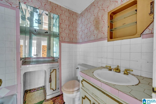 bathroom featuring tile walls, vanity, and toilet