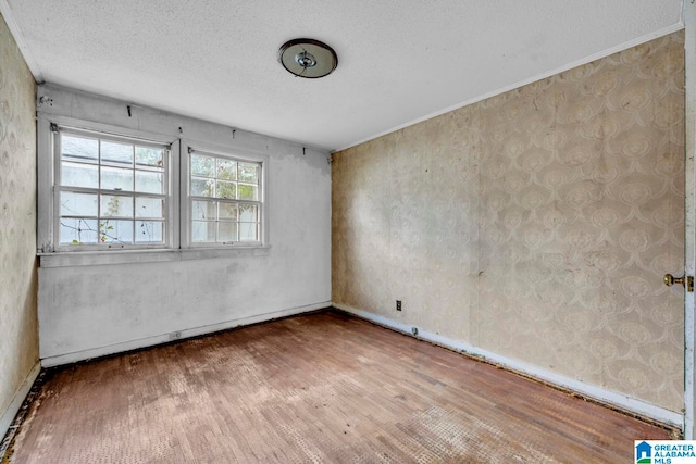 spare room featuring a textured ceiling and hardwood / wood-style floors