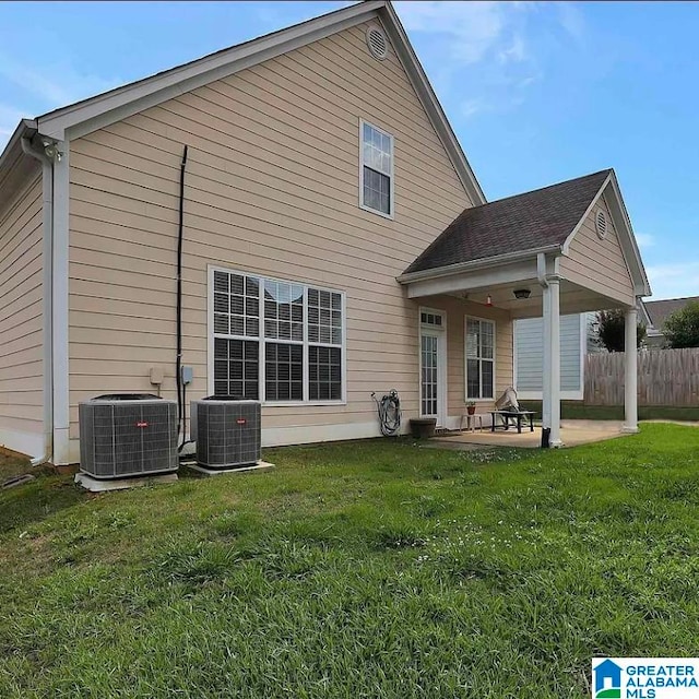 rear view of house featuring a lawn, central AC, and a patio area