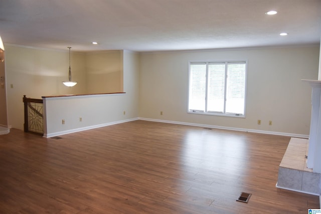 unfurnished living room featuring ornamental molding and dark hardwood / wood-style flooring