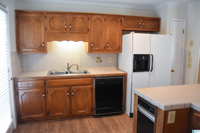 kitchen with black dishwasher, tile countertops, oven, light hardwood / wood-style flooring, and sink