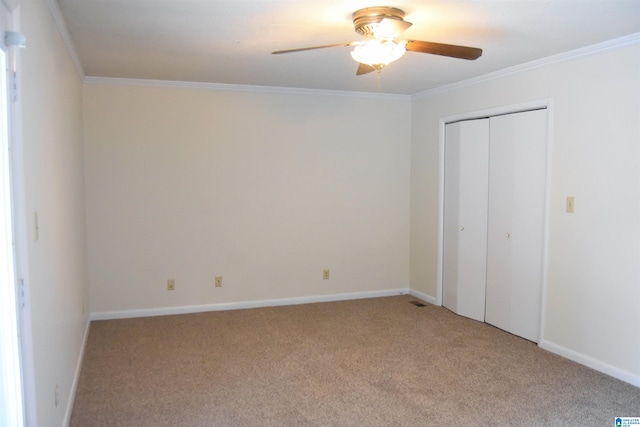 unfurnished bedroom with ornamental molding, a closet, ceiling fan, and light colored carpet