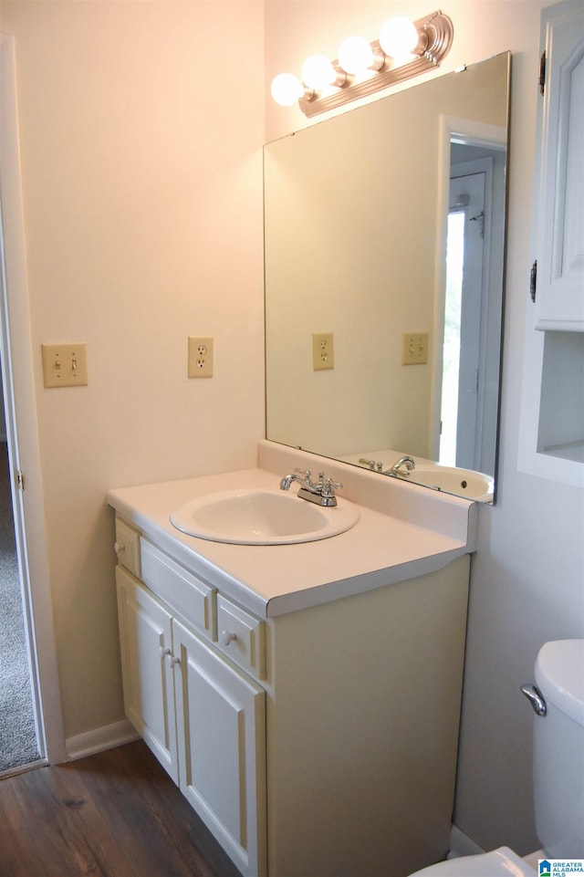 bathroom featuring vanity, toilet, and hardwood / wood-style flooring