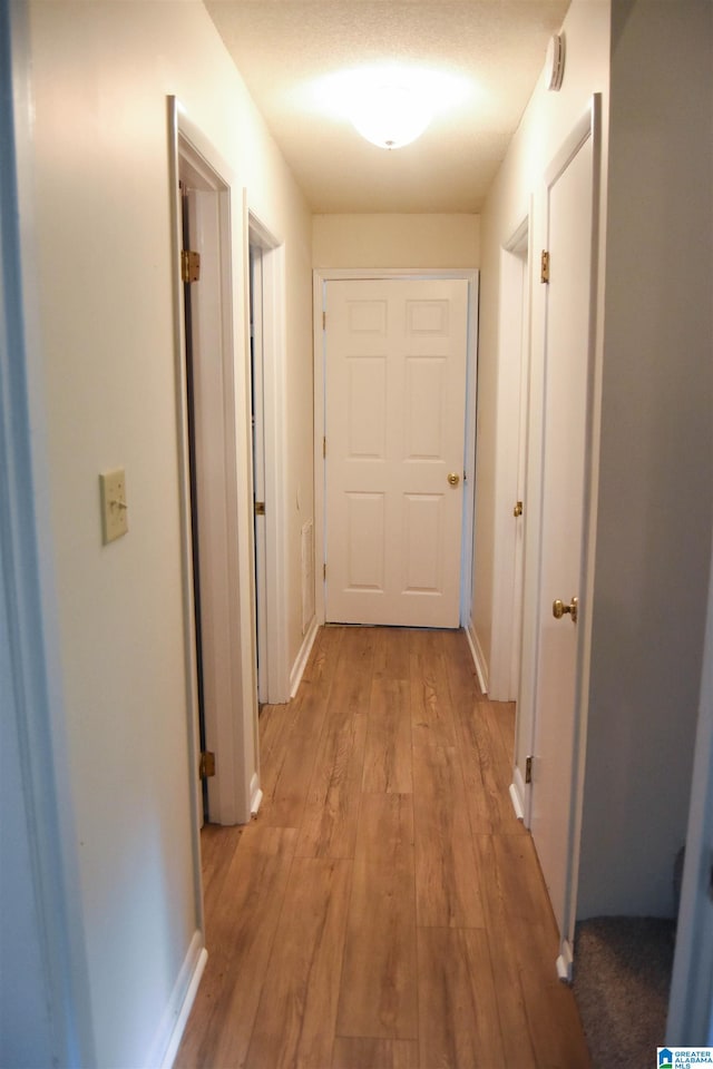 corridor with light hardwood / wood-style floors