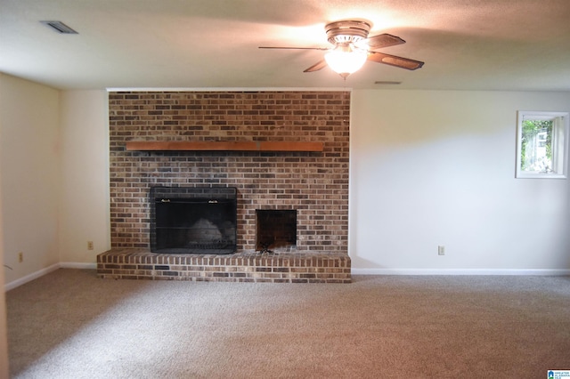 unfurnished living room with carpet, ceiling fan, and a brick fireplace