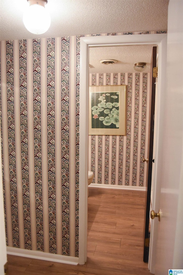 interior details featuring a textured ceiling and hardwood / wood-style flooring