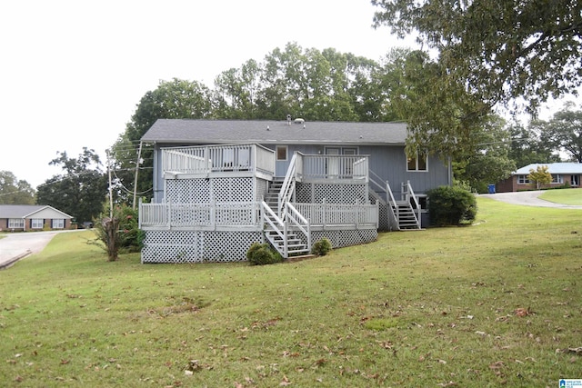 rear view of property with a wooden deck and a yard