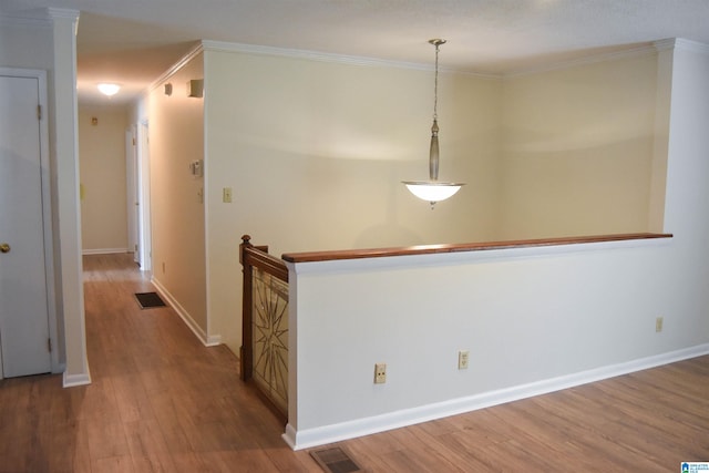 hall with ornamental molding and hardwood / wood-style flooring