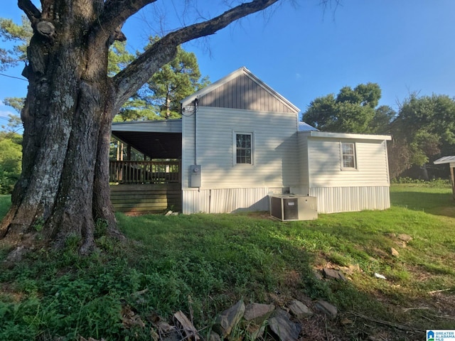 back of house featuring a lawn and central air condition unit