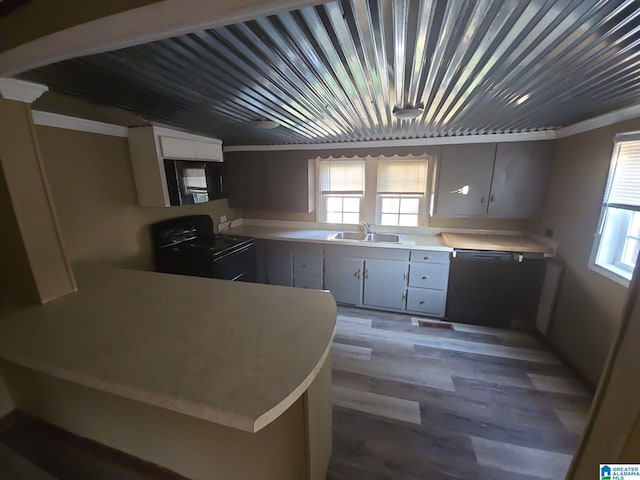 kitchen with a wealth of natural light, black appliances, light countertops, and a sink