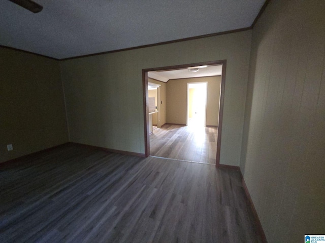 unfurnished room featuring baseboards, crown molding, and wood finished floors