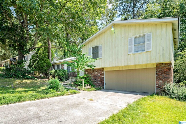 tri-level home featuring a garage and a front lawn