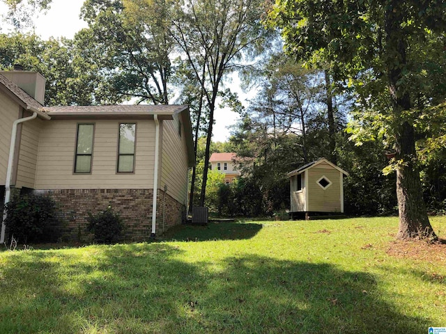 view of yard featuring a storage shed and central AC