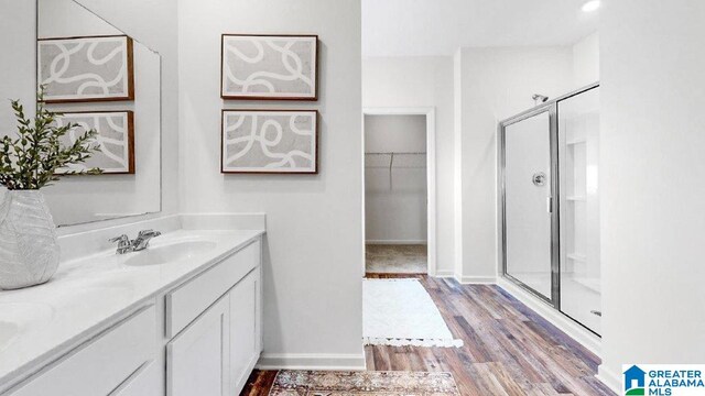 bathroom with vanity, hardwood / wood-style flooring, and walk in shower