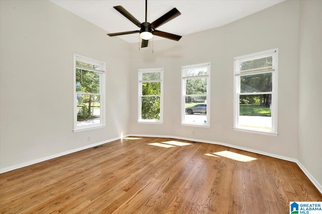 empty room with light hardwood / wood-style flooring, ceiling fan, and a healthy amount of sunlight