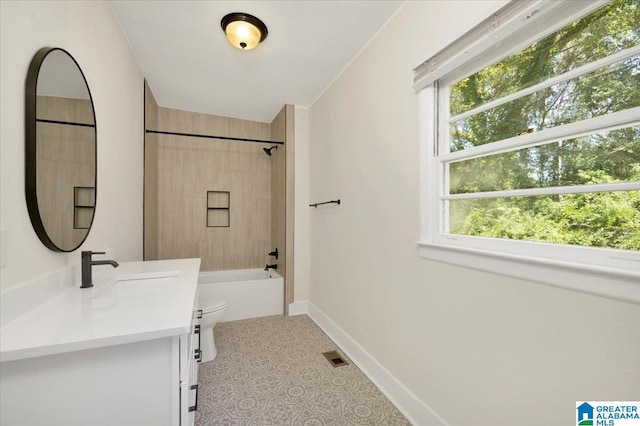 full bathroom featuring tiled shower / bath, vanity, toilet, and a wealth of natural light