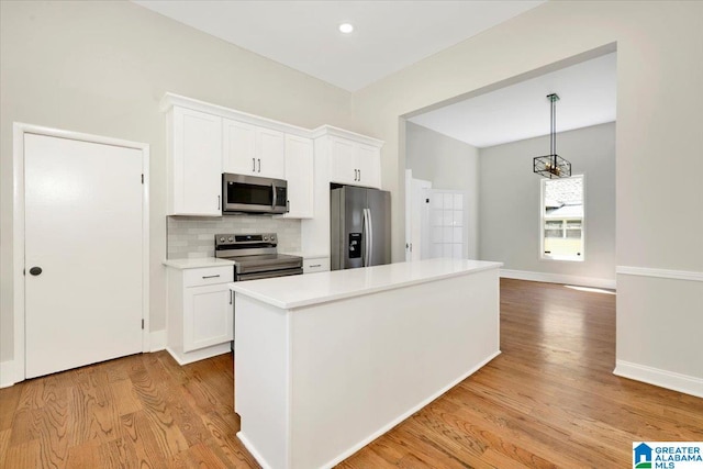 kitchen featuring white cabinets, appliances with stainless steel finishes, and light wood-type flooring