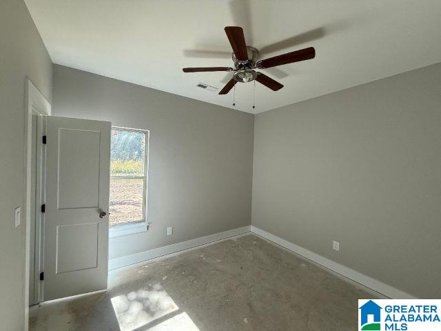 empty room with baseboards, visible vents, ceiling fan, and concrete flooring