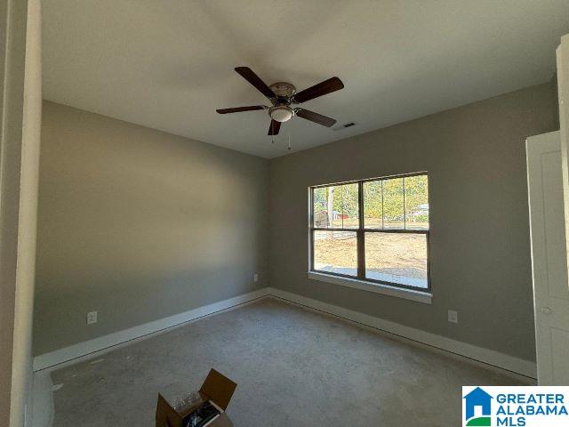 spare room featuring ceiling fan and baseboards