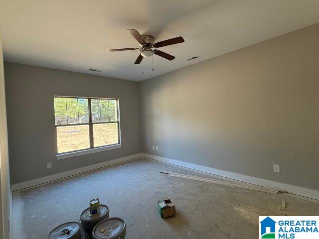 unfurnished room featuring baseboards, ceiling fan, and visible vents