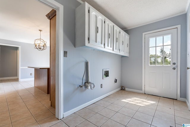 laundry room with washer hookup, hookup for an electric dryer, a textured ceiling, light tile patterned floors, and crown molding