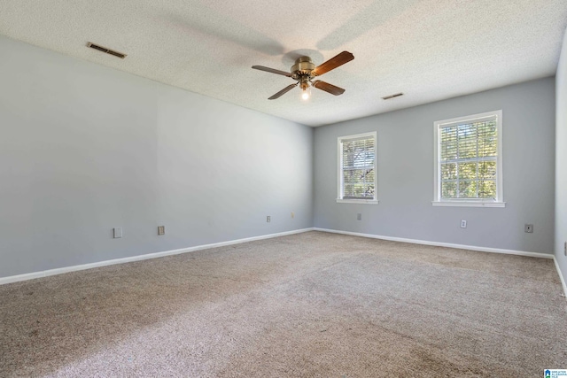 carpeted spare room with ceiling fan and a textured ceiling