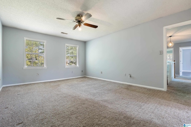 carpeted empty room featuring ceiling fan and a textured ceiling