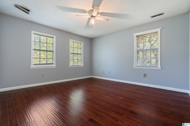 spare room with a textured ceiling, dark wood-type flooring, and ceiling fan