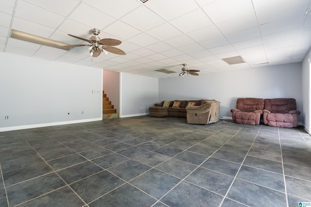 unfurnished living room with dark tile patterned floors, ceiling fan, and a paneled ceiling