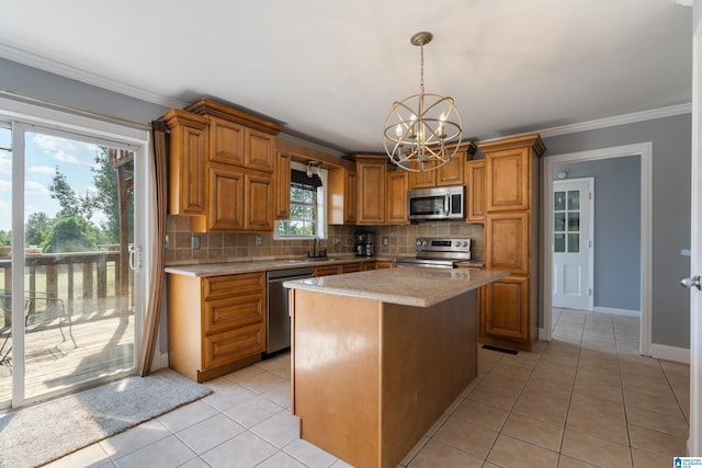 kitchen with a notable chandelier, stainless steel appliances, a center island, and plenty of natural light