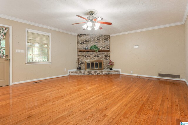 unfurnished living room with visible vents, a ceiling fan, ornamental molding, and wood finished floors
