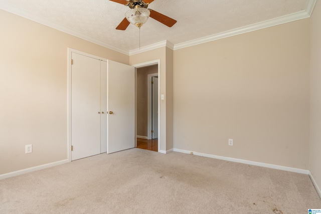 unfurnished room with crown molding, light carpet, a textured ceiling, and ceiling fan