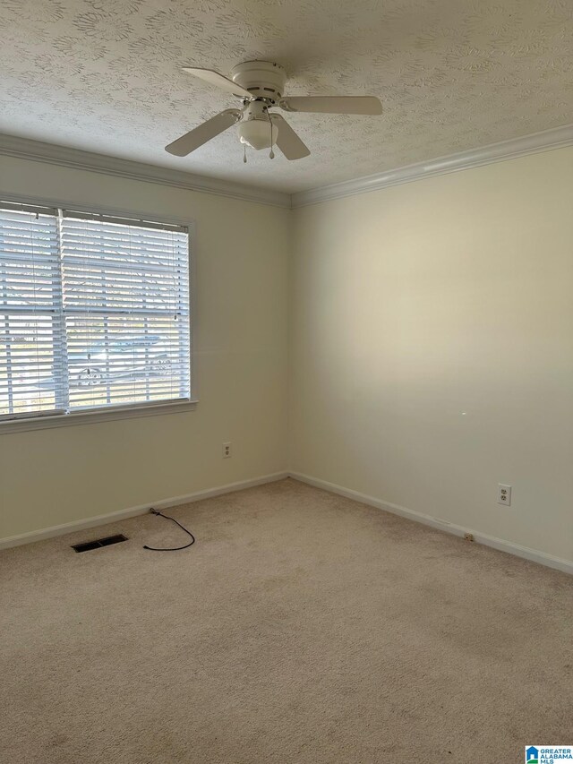 unfurnished room featuring a textured ceiling, ceiling fan, ornamental molding, and visible vents