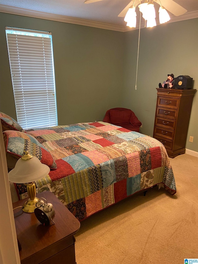 carpeted bedroom featuring ceiling fan and crown molding