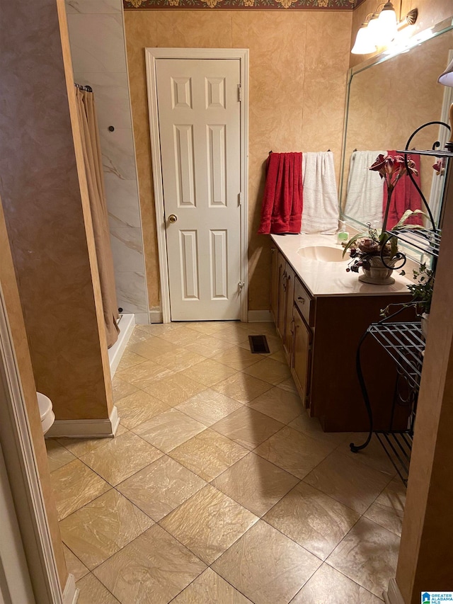 bathroom with walk in shower, vanity, and toilet