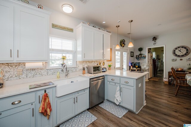 kitchen with hanging light fixtures, decorative backsplash, kitchen peninsula, stainless steel dishwasher, and dark hardwood / wood-style floors