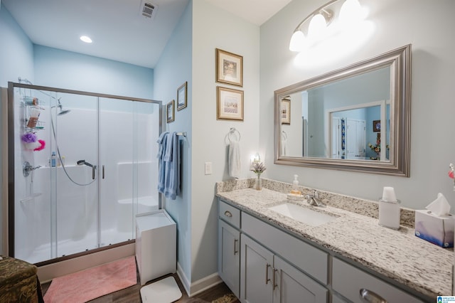 bathroom with vanity, a shower with door, and hardwood / wood-style flooring