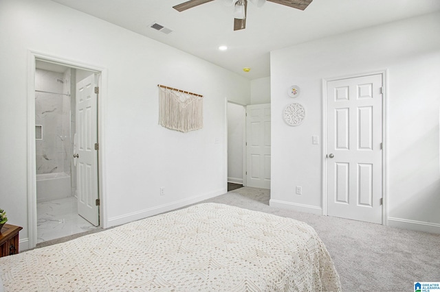 bedroom with ceiling fan, light colored carpet, and ensuite bathroom