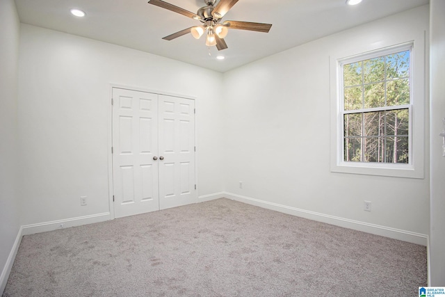 unfurnished bedroom featuring carpet, ceiling fan, and a closet