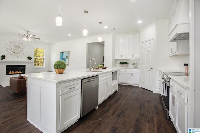 kitchen with appliances with stainless steel finishes, hanging light fixtures, sink, and white cabinets