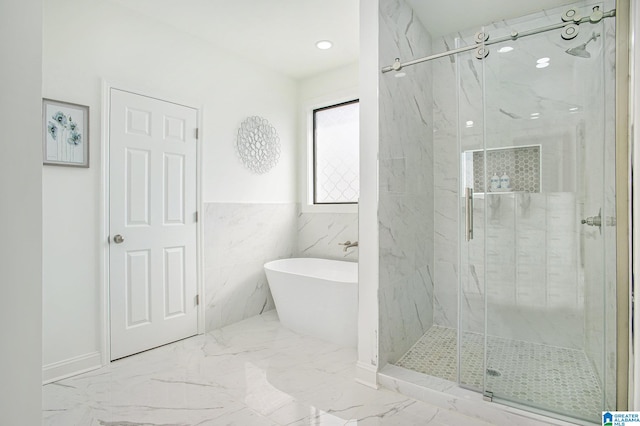 bathroom with shower with separate bathtub and tile walls