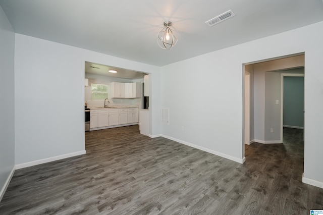 unfurnished living room featuring dark hardwood / wood-style floors and sink