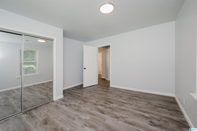 unfurnished bedroom featuring a closet and hardwood / wood-style floors