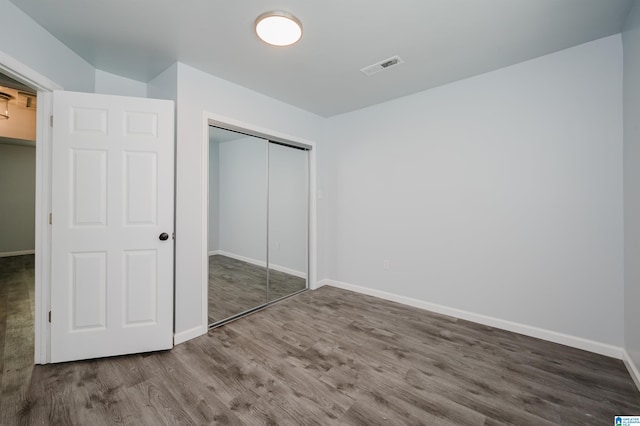 unfurnished bedroom with a closet and hardwood / wood-style flooring