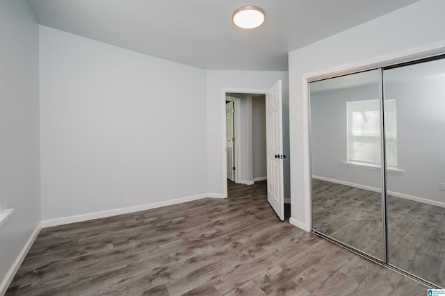 unfurnished bedroom featuring wood-type flooring and a closet