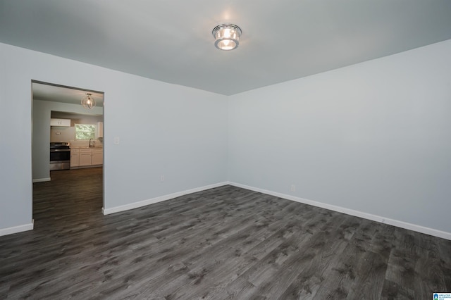 empty room featuring sink and dark hardwood / wood-style flooring