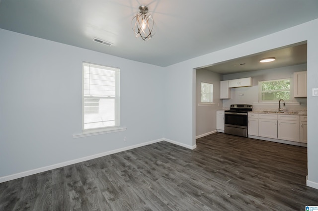 kitchen with stainless steel range with electric stovetop, sink, dark wood-type flooring, and white cabinets